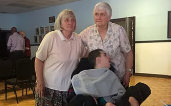 two elderly women and disabled man